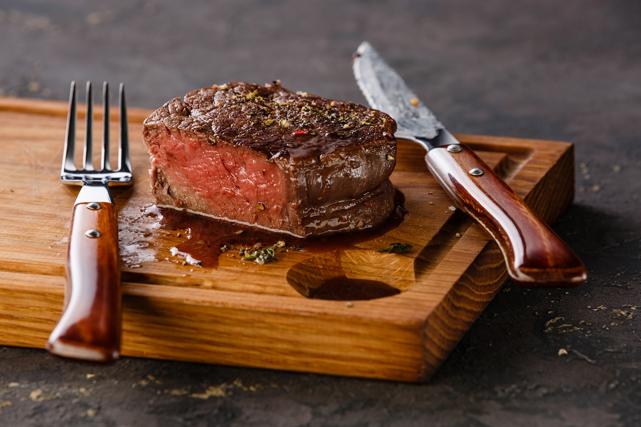 Filet-Mignon-Steak-on-wooden-board-on-black-background