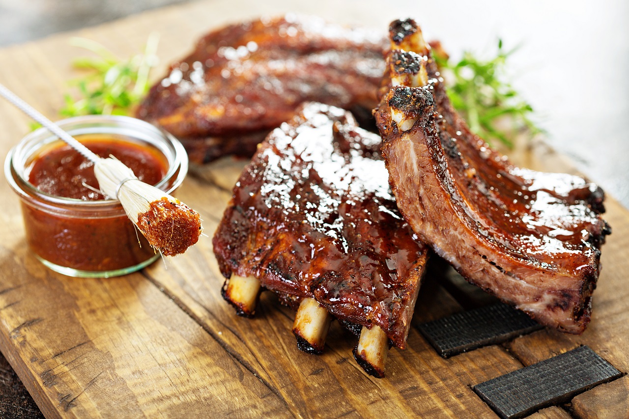 Grilled-and-smoked-ribs-with-barbeque-sauce-on-a-carving-board